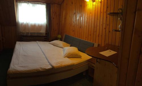 a bedroom with a bed and a table and a window at Hotel Bucegi Portile Regatului in Paraul Rece