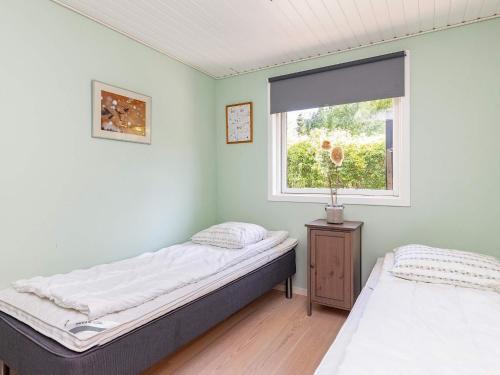 two beds in a room with a window at 6 person holiday home in Ålbæk-By Traum in Ålbæk