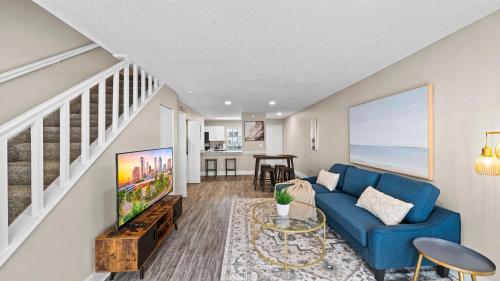 a living room with a blue couch and a table at Cozy Townhouse - Gym Pool Golf Fast WiFi 2B2B in Tampa