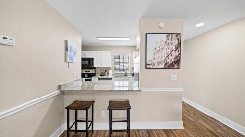 a kitchen with two stools at a counter at Cozy Townhouse - Gym Pool Golf Fast WiFi 2B2B in Tampa