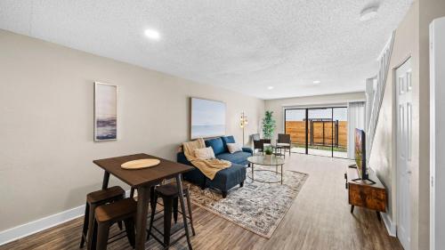 a living room with a blue couch and a table at Cozy Townhouse - Gym Pool Golf Fast WiFi 2B2B in Tampa