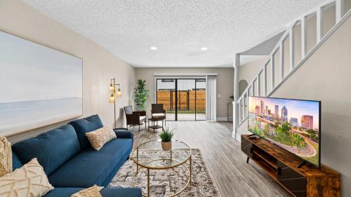 a living room with a blue couch and a tv at Cozy Townhouse - Gym Pool Golf Fast WiFi 2B2B in Tampa