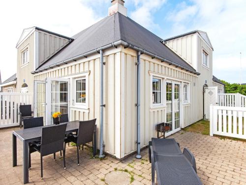 a small white house with a table and chairs at 6 person holiday home in Ringk bing in Ringkøbing