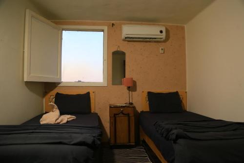 a room with two beds and a window at Castle Hotel in Cairo