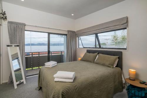 a bedroom with a bed with two towels on it at Aqua Soleil Villas in Whitianga
