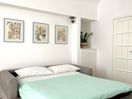 ドルチェアックアにあるDa I Ciarui casa vacanzeの壁に3枚の写真が飾られたベッドルームのベッド1台