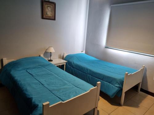 Habitación con 2 camas, mesa y ventana en Rincón Salteño en Salta
