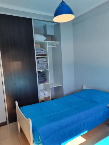 1 dormitorio con cama azul y armario en Rincón Salteño en Salta