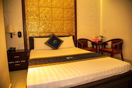a bedroom with a bed with a black and gold headboard at Phuc Hotel in Cao Lãnh