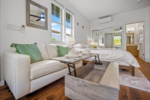a living room with a white couch and a bed at Studio Nene - Mountains, Beaches, King Bed, Pool & Gym in Waianae