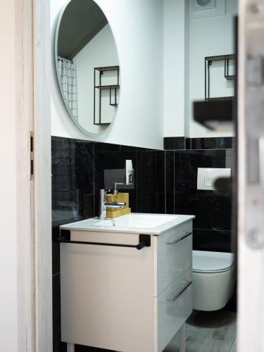 a bathroom with a sink and a mirror and a toilet at Apartamenty MARINA Puck in Puck