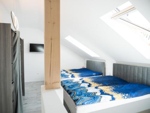 a bedroom with a bed with a blue comforter at Apartamenty MARINA Puck in Puck