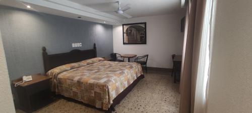 um quarto com uma cama, uma mesa e uma cadeira em Hotel Habana em Cidade do México