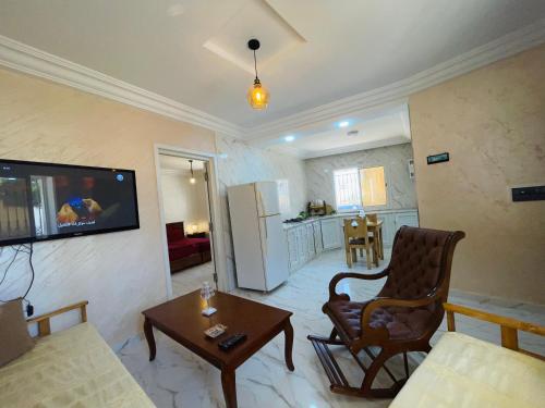 a living room with a couch and a tv on a wall at Seaside Guest House in Ghār al Milḩ