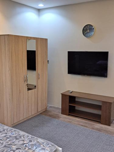 a bedroom with a flat screen tv on the wall at استوديو ريفي تنومه in Tanomah