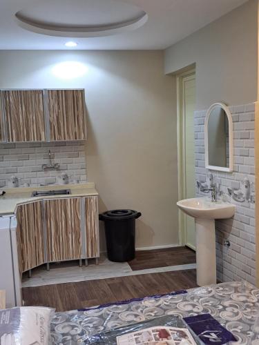 a bathroom with a sink and a toilet and a mirror at استوديو ريفي تنومه in Tanomah