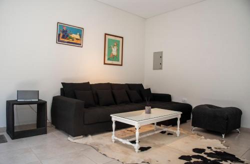 sala de estar con sofá negro y mesa en my place in MDZ en Godoy Cruz