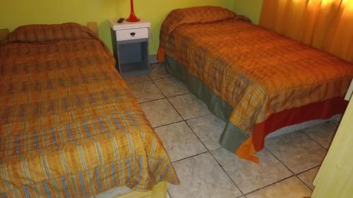 two beds sitting next to each other in a room at Descanso Los Alamos in Plottier