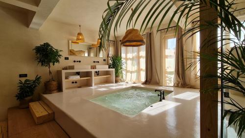 a bathroom with a hot tub in a room with plants at Biophilia Luxury Lofts in Beirut