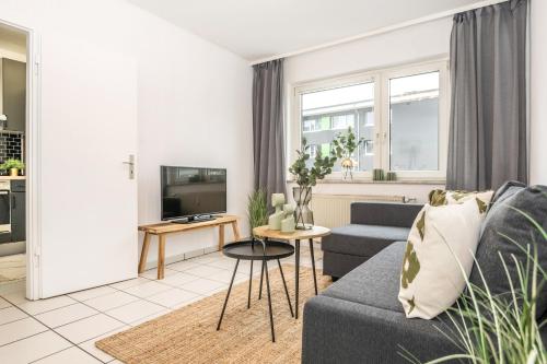 un soggiorno con divano e TV di Cityflat Balcony - WIFI, SmartTV, full Kitchen, Bathtub - Pottbude a Essen