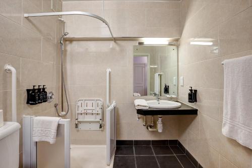W łazience znajduje się umywalka i prysznic. w obiekcie Bedford Hotel w Londynie