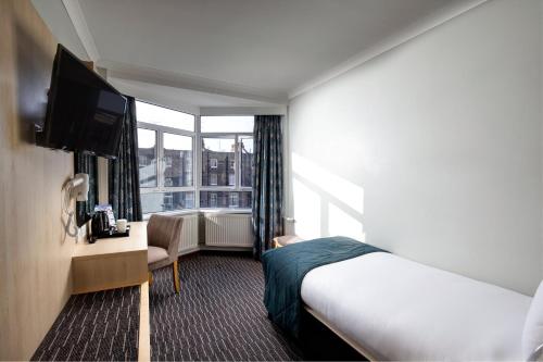 a hotel room with a bed and a television at Bedford Hotel in London