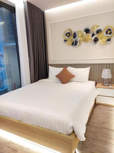 a bedroom with a white bed and a window at Kings House Apec Condotel Phú Yên in Tuy Hoa