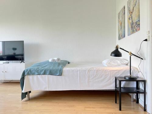 a bedroom with a bed and a tv and a lamp at Studio Apartment In Herlev, Herlevgrdsvej 4, in Herlev
