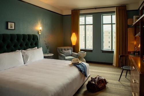 a hotel room with a large bed and a chair at Hotel Emeline in Charleston