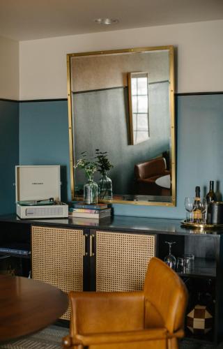 a mirror and a table and a chair in a room at Hotel Emeline in Charleston