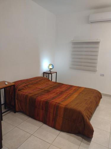 a bedroom with a bed and a desk and a window at Lomas del Mirador in San Fernando del Valle de Catamarca