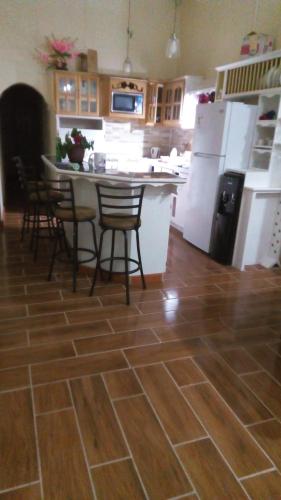a kitchen with a table and chairs and a refrigerator at Alexander's Apartment in Carriacou