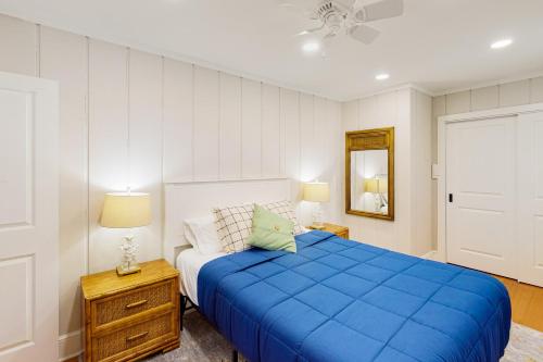 a bedroom with a blue bed and a mirror at Pine Whiff Beach House in Annapolis