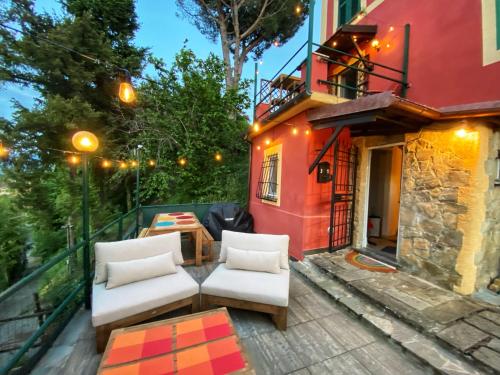 un patio con 2 sillas blancas y un edificio en La Casa Rossa Arcola Con Vista, en Arcola