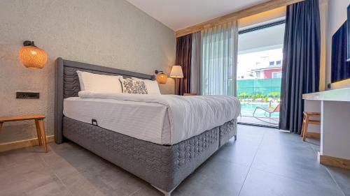a bedroom with a bed and a large window at S-Cape Hotel Fethiye in Fethiye