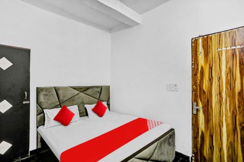 sypialnia z łóżkiem z czerwonymi poduszkami w obiekcie OYO Flagship 81043 Paradise Inn w mieście Panchli