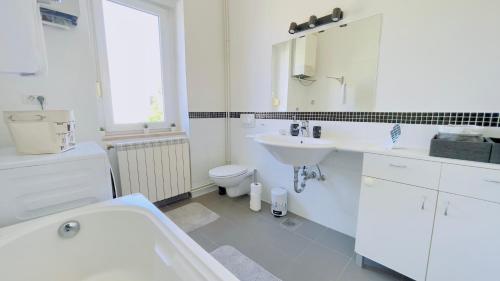 a white bathroom with a sink and a toilet at Apartment Reful in Kraljevica