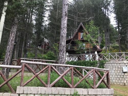 a cabin in the woods behind a fence at Chalet Natura Sport&Relax in Cavaliere