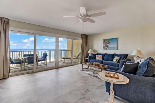 a living room with a blue couch and a balcony at Oceanfront w Beach Access in Amelia Island