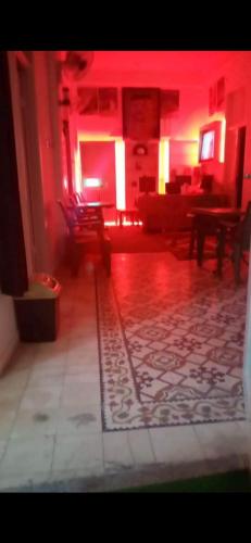 a living room with red lighting and a couch and chairs at Jawal Hotel in Amman