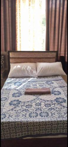 Bett mit einem Kopfteil aus Holz und einem Kissen in der Unterkunft Jawal Hotel in Amman