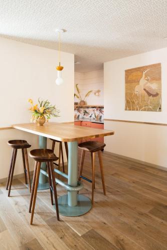 a dining room with a wooden table and stools at The Ryder Hotel in Charleston