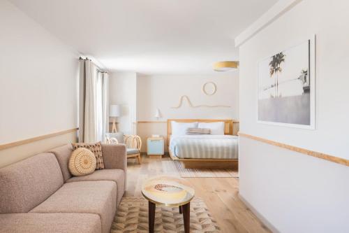 a living room with a couch and a bed at The Ryder Hotel in Charleston