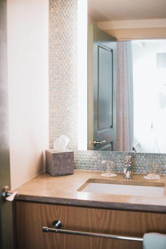 a bathroom with a sink and a mirror at The Ryder Hotel in Charleston