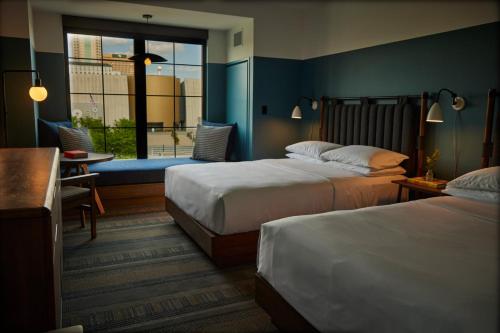 a hotel room with two beds and a window at The Junto Hotel in Columbus