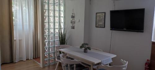 sala de estar con mesa blanca y TV en Apartman Campo, en Šibenik