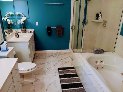 a bathroom with a tub and a toilet and a sink at Blue Ruby at Grice-Fearing B&B in Elizabeth City