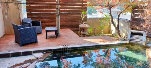 a swimming pool with chairs and a table and a fire hydrant at 旬樹庵　菊水 in Chikuma