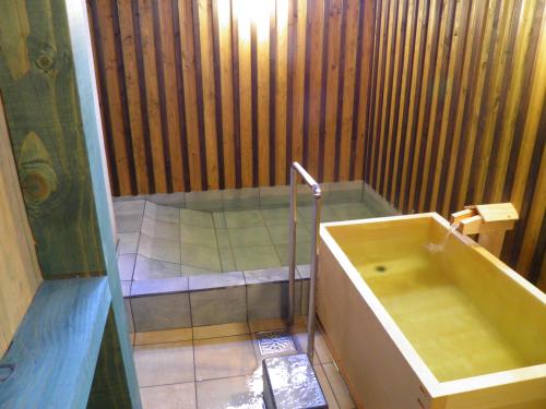 a bathroom with a bath tub and a sink at 旬樹庵　菊水 in Chikuma