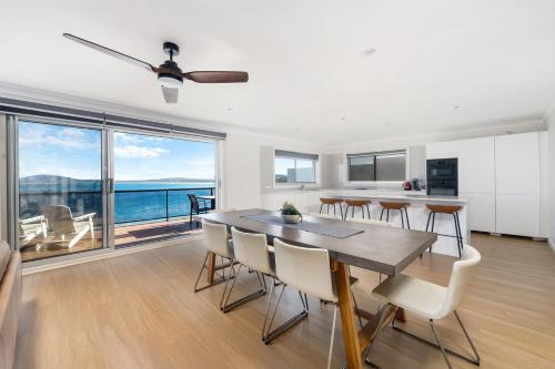 a kitchen and dining room with a table and chairs at Amaroo in Gerroa